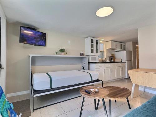 a bedroom with a bed and a kitchen at Beach Road - Bari in Siesta Key