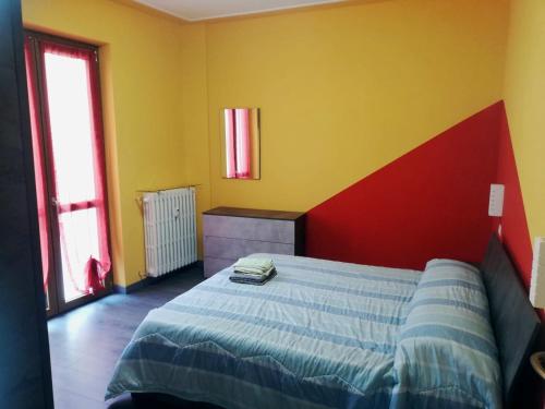 a bedroom with a bed with a red and yellow wall at Da Alessandro in Biella