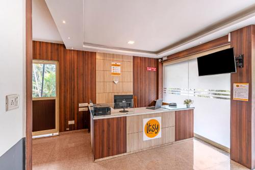 AnavirattyにあるItsy Hotels Abrigoの薄型テレビ付きのフロントデスクがあるオフィスを提供しています。