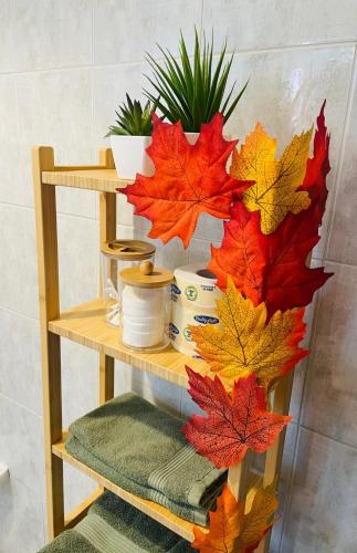 a wooden shelf with autumn leaves on it at MXP Relax House in Samarate