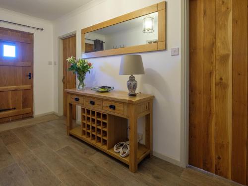 a room with a table with a lamp and a mirror at Greenridge in Totland