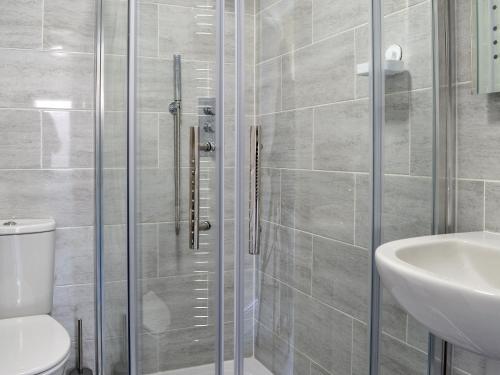 a bathroom with a shower and a toilet and a sink at The Hideaway in Sheringham