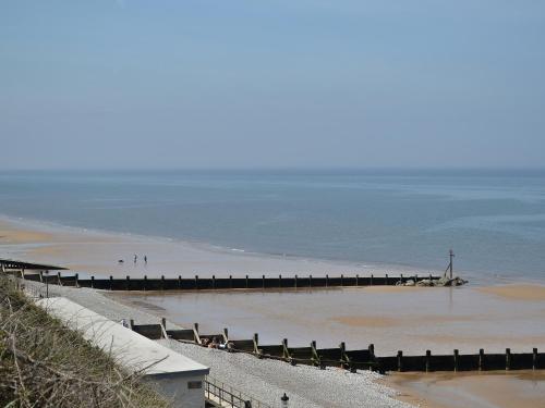 a beach with a pier in the water at The Hideaway in Sheringham