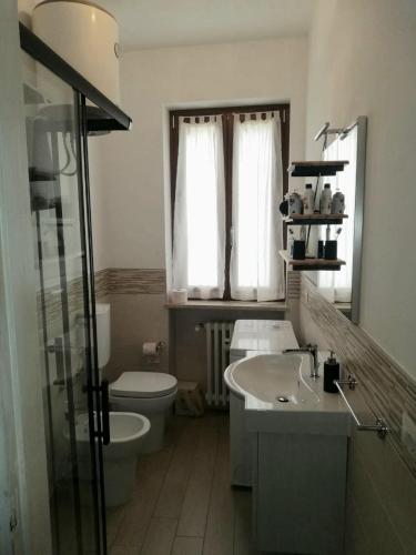 a bathroom with a sink and a toilet and a window at Da Alessandro in Biella