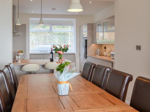 a dining room table with a vase of flowers on it at Estuary View in Lympstone