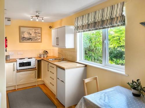 a kitchen with a sink and a window at The Sail Room in Saint Mawes
