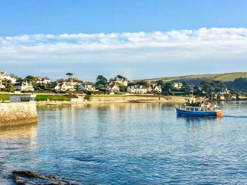 a boat on a river with a town in the background at The Sail Room in Saint Mawes