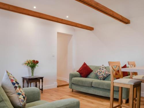 a living room with a couch and a table at Brooklands Farm Cottage in Biggleswade