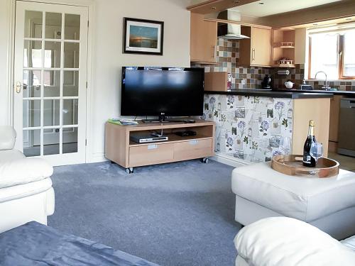 Una sala de estar con un televisor de pantalla plana sobre una mesa. en The Gatehouse, en Sewerby