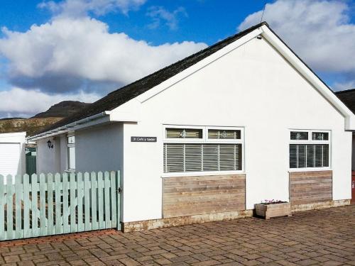 a white house with a fence in front of it at Black Rock Hideaway in Porthmadog