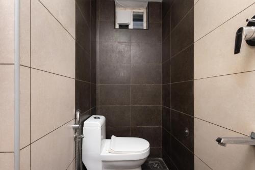a bathroom with a white toilet in a room at Simqo By Nexa Hotels Group in Kozhikode