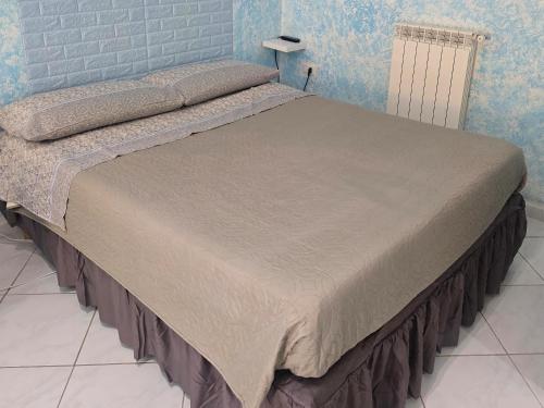 a large bed in a bedroom with blue walls at Appartamento sofí in Fiumicino