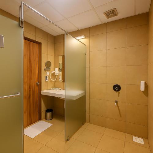 a bathroom with a shower and a sink at The Sky Imperial Bapu's Resort, Dwarka in Dwarka