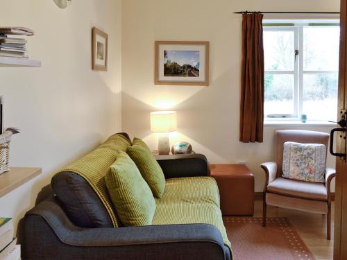 ein Wohnzimmer mit einer Couch und einem Sessel in der Unterkunft Rose Cottage - W41462 in Sturminster Newton