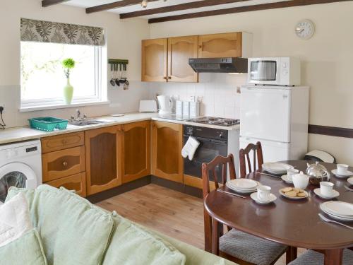 Una cocina con una mesa y un comedor. en Walnut, en Thornbury