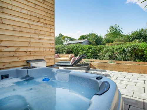 a jacuzzi tub in the backyard of a house at Brook Cottage-Uk44378 in Washford