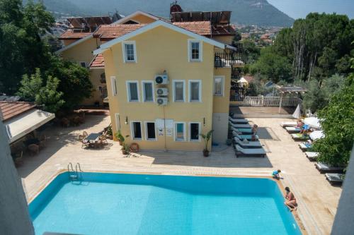 a villa with a swimming pool in front of a house at Güneş Boutique Hotel - Oludeniz in Oludeniz