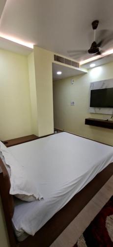 a bedroom with a white bed in a room at Hotel Mahavir Inn in Gaya