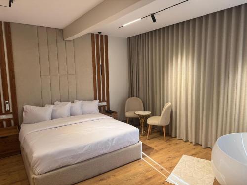 a bedroom with a white bed and a table and chairs at Palacio Pyramids Hotel in Cairo
