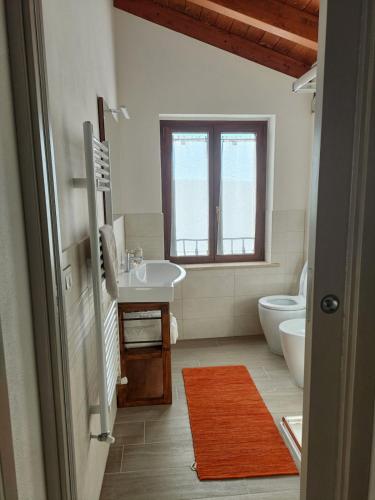 a bathroom with a sink and a toilet at La Casetta Rosa in San Venanzo