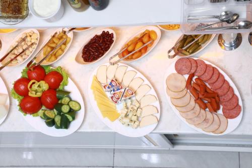 a bunch of different types of meats and vegetables on plates at Central Plaza Hotel in Urganch