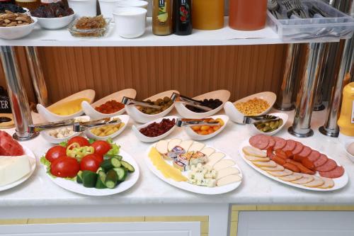 a table with plates of different types of food at Central Plaza Hotel in Urganch