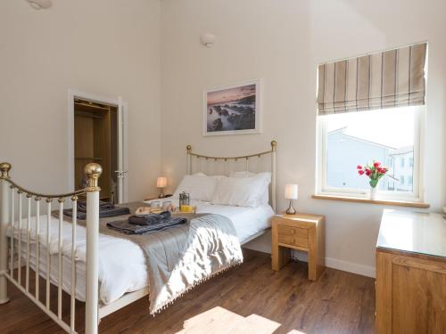 a bedroom with a white bed and a window at Broad Reach - 28121 in Fritton Norfolk