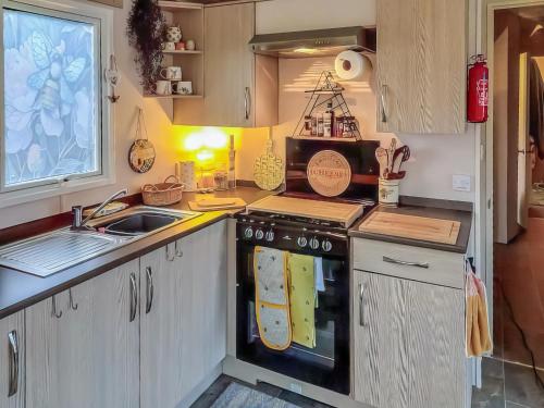 a kitchen with a stove top oven next to a sink at The Hive in Hawick