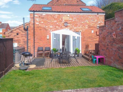 a patio with a table and chairs on a deck at Barn Cottage - E5560 in Winthorpe