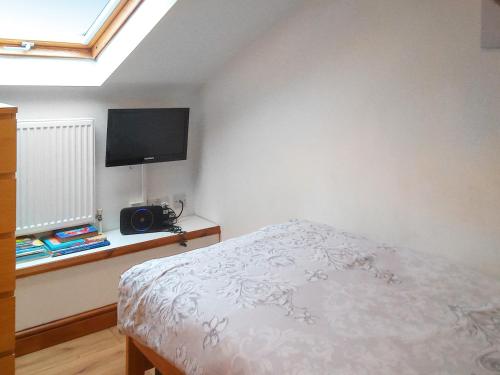 a bedroom with a bed and a flat screen tv at Barn Cottage - E5560 in Winthorpe