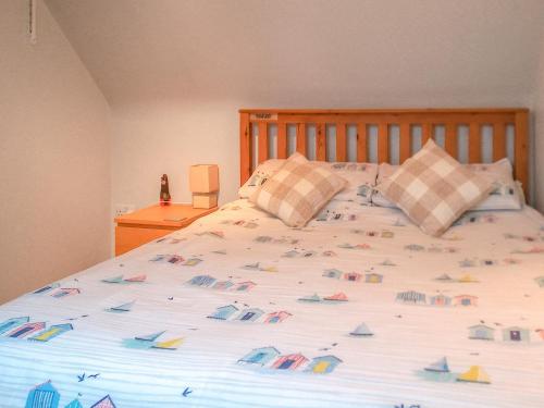a bedroom with a large bed with boats on it at Barn Cottage - E5560 in Winthorpe