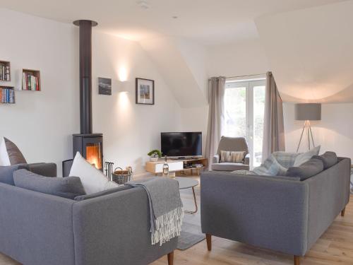 a living room with two couches and a fireplace at Kenmore Lodge in Kenmore