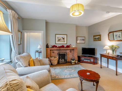 a living room with a couch and a fireplace at Snowshill in Alnwick