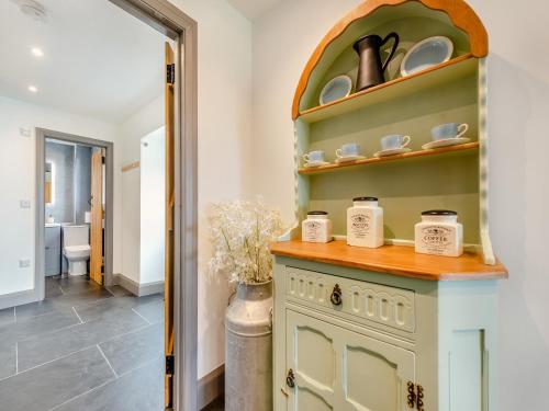 a kitchen with a green cabinet with dishes on it at Park Clement in Clydey