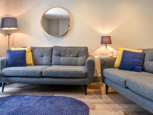 a living room with two couches and a mirror at Garden Flat in Ryde