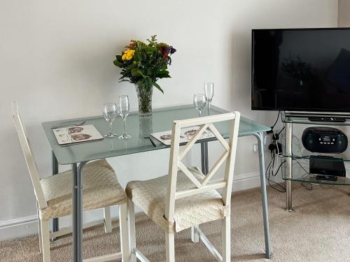 a glass table with glasses and a vase of flowers at Chaplin in Legbourne