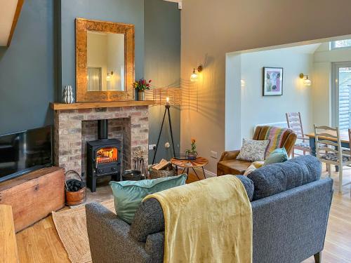 SaltonにあるLockwood Barnのソファと暖炉のあるリビングルーム