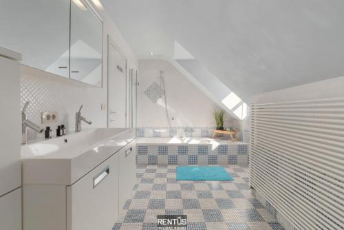 a white bathroom with a sink and a shower at Villa Hoge Duin - spacious luxury villa with large garden in Koksijde