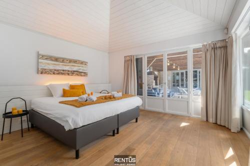 a bedroom with a bed and a large window at Villa Hoge Duin - spacious luxury villa with large garden in Koksijde