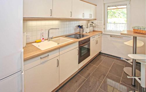 a kitchen with white cabinets and a sink at Ferienhaus Kratzeburg in Kratzeburg