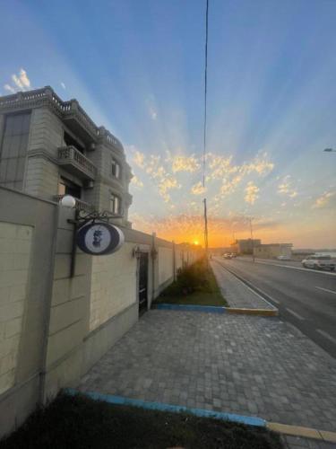 a building with a clock on the side of a street at NovART Gallery & Sea Hotel in Sumqayyt