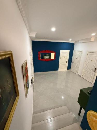 an empty hallway with blue walls and white doors at NovART Gallery & Sea Hotel in Sumqayyt