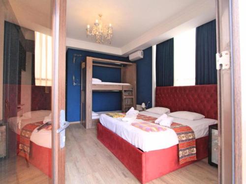 a bedroom with two beds and a chandelier at NovART Gallery & Sea Hotel in Sumqayyt