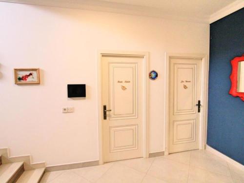 two white doors in a room with a staircase at NovART Gallery & Sea Hotel in Sumqayyt