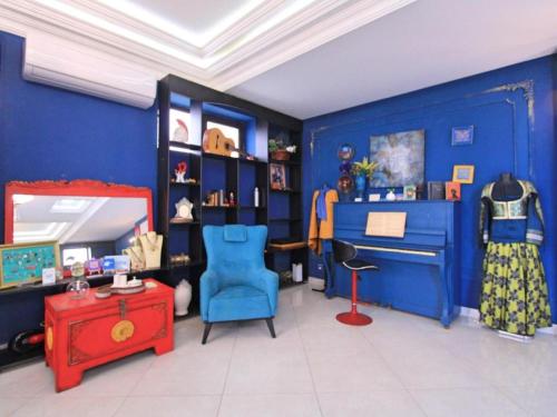 a room with blue walls and a blue chair and a table at NovART Gallery & Sea Hotel in Sumqayyt