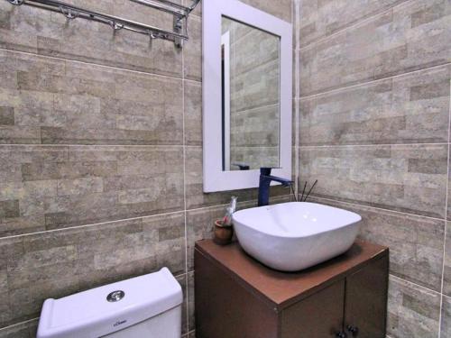 a bathroom with a sink and a toilet and a mirror at NovART Gallery & Sea Hotel in Sumqayyt