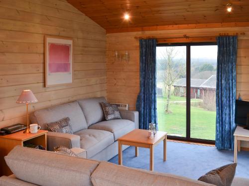 ein Wohnzimmer mit Couch und großem Fenster in der Unterkunft Lodge 59 in Woolfardisworthy