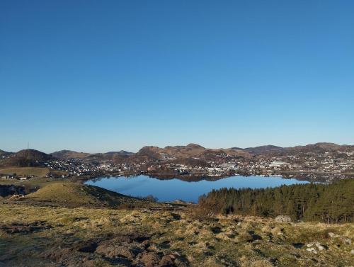 a view of a lake with a city in the background at Spacious, quiet and cosy apartment near Kongeparken & Pulpit Rock in Ålgård