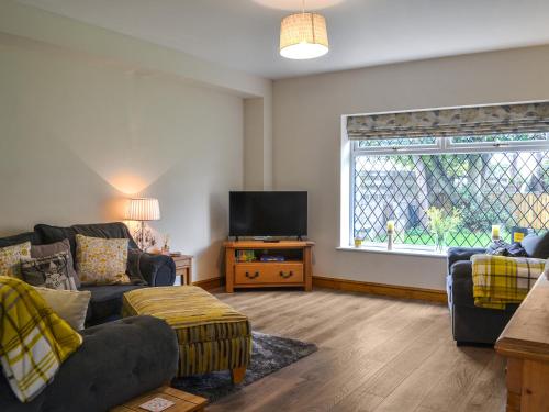 un soggiorno con due divani e una TV di Heatherdene - Fern Cottage a Wilberfoss