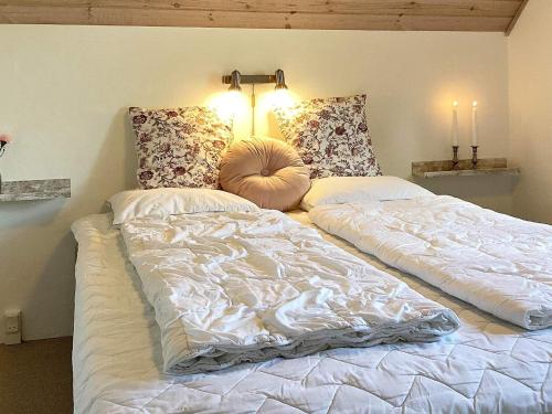 a large bed with two pillows on top of it at 5 star holiday home in Væggerløse in Bøtø By